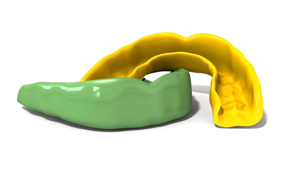 Green and yellow sports guards on white background